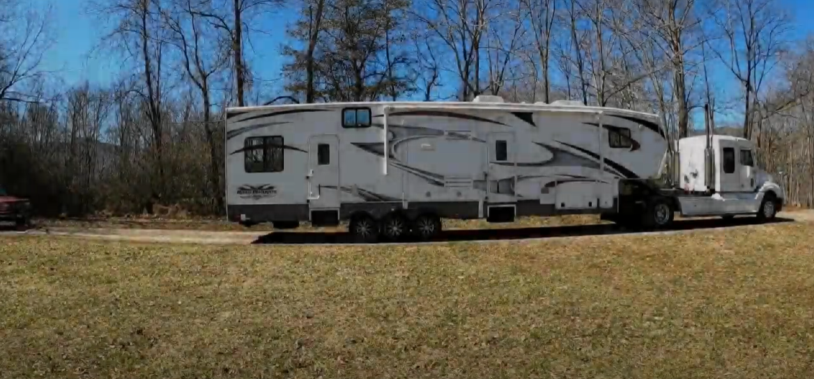 What is the best way to back up an RV while towing a car?